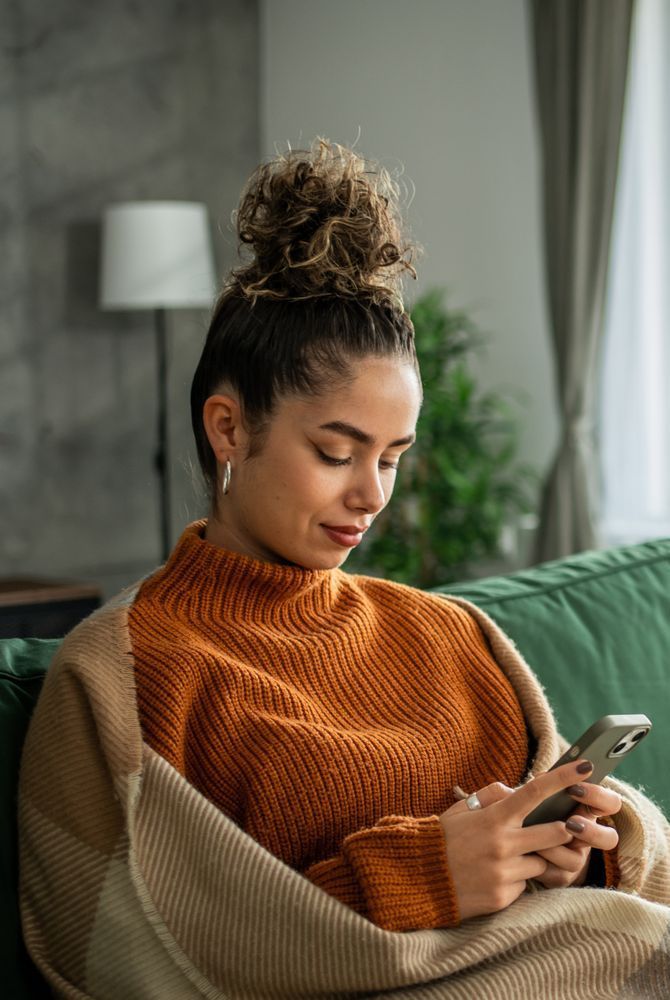 Creator relaxing on a sofa with a warm drink for a mindful break